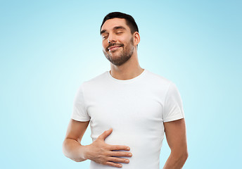 Image showing happy full man touching tummy over blue background