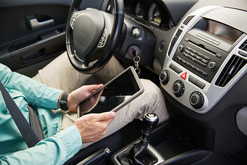 Image showing close up of young man with tablet pc driving car