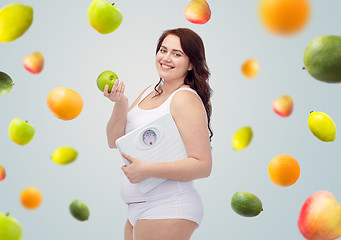 Image showing happy young plus size woman holding scales