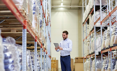 Image showing happy businessman with tablet pc at warehouse