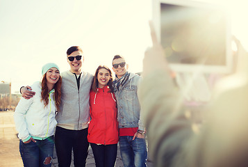 Image showing happy teenage friends with tablet pc photographing