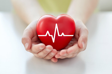 Image showing close up of hand with cardiogram on red heart