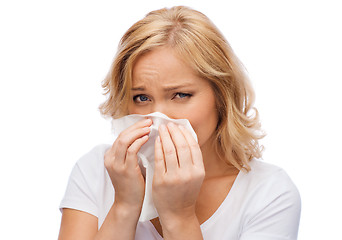 Image showing unhappy woman with paper napkin blowing nose