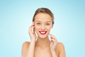 Image showing smiling young woman with pink lipstick on lips