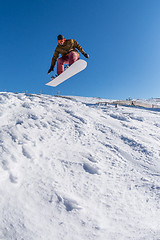 Image showing Snowboarder jumping against blue sky