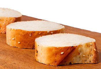 Image showing Delicious fresh bread sliced on a wooden board