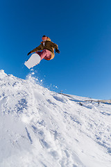 Image showing Snowboarder jumping against blue sky