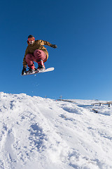 Image showing Snowboarder jumping against blue sky