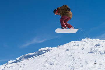 Image showing Snowboarder jumping against blue sky