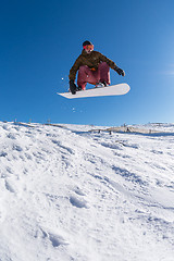 Image showing Snowboarder jumping against blue sky