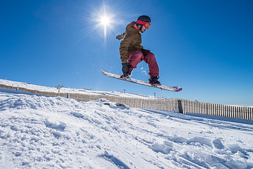 Image showing Snowboarder jumping against blue sky