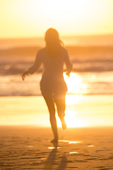 Image showing Woman running on the beach in sunset.