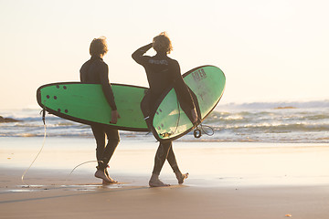 Image showing Surfers on beach with surfboard.