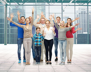 Image showing group of smiling people waving hands