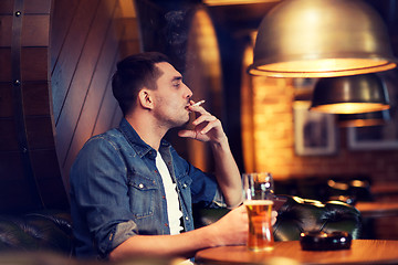 Image showing man drinking beer and smoking cigarette at bar