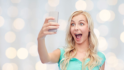 Image showing smiling young woman taking selfie with smartphone