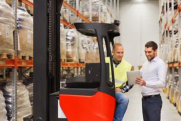 Image showing men with tablet pc and forklift at warehouse