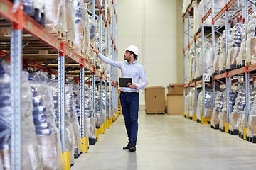 Image showing happy businessman with clipboard at warehouse