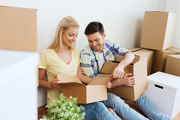 Image showing smiling couple with many boxes moving to new home