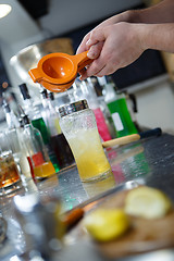 Image showing Bartender is straining cocktail in a glass