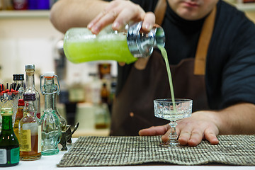 Image showing barman pouring a pink cocktail drink 