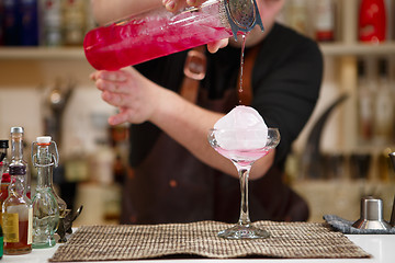 Image showing barman pouring a pink cocktail drink 