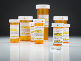 Image showing Medicine Bottles and Pills on Reflective Surface With Grey Backg