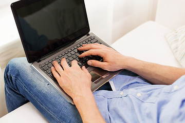 Image showing close up of man typing on laptop computer at home