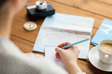 Image showing close up of traveler hands with notepad and pencil