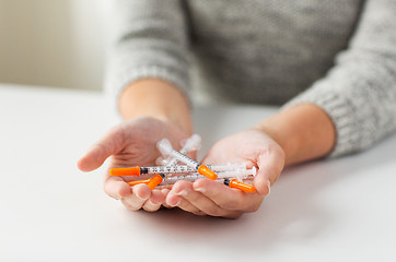 Image showing close up of woman hands holding insulin syringes