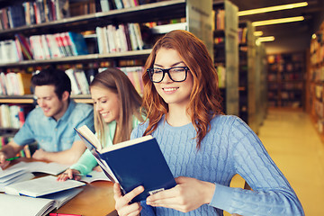 Image showing happy students reading books in library