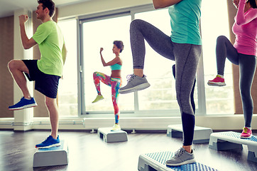 Image showing group of people raising legs on step platforms