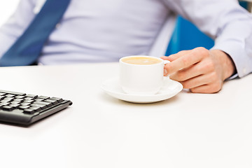 Image showing close up of businessman hand with coffee cup