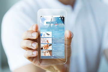 Image showing close up of hand with business news on smartphone