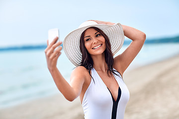 Image showing smiling young woman taking selfie with smartphone