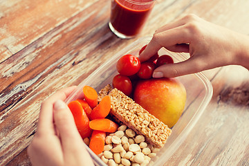 Image showing close up of hands with vegetarian food in box