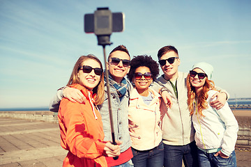 Image showing smiling friends taking selfie with smartphone