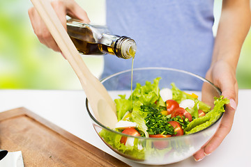 Image showing close up of woman cooking vegetable salad at home