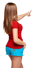 Image showing Back view of a young female pointing at blank copy space