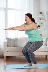 Image showing plus size woman exercising on mat at home