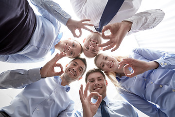 Image showing smiling group of businesspeople standing in circle