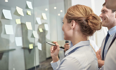 Image showing smiling business people with marker and stickers