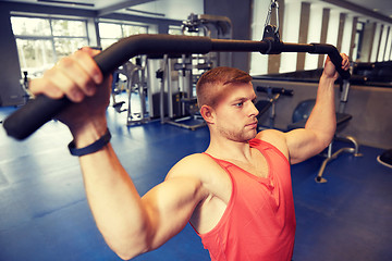 Image showing man flexing muscles on cable machine gym