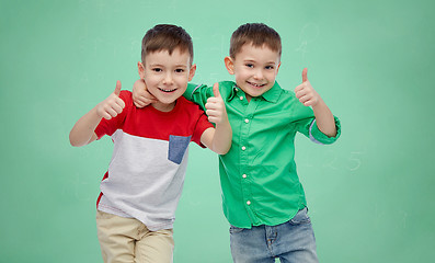 Image showing happy boys showing thumbs up over school board