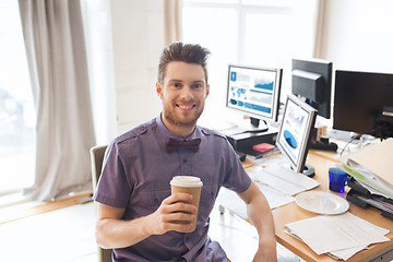 Image showing happy creative male office worker drinking coffee