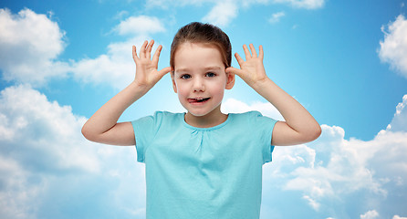 Image showing happy little girl having fun and making ears