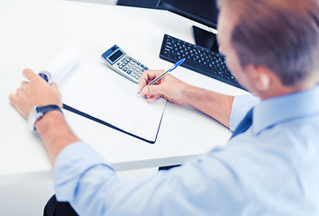 Image showing businessman with notebook and calculator