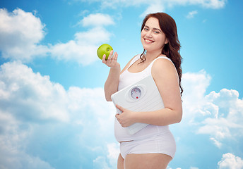 Image showing happy young plus size woman holding scales