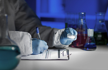 Image showing close up of scientist writing test results in lab