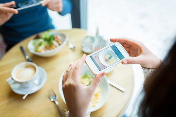 Image showing close up of couple picturing food by smartphone